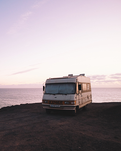 Camper parked on the beach in front of a lake